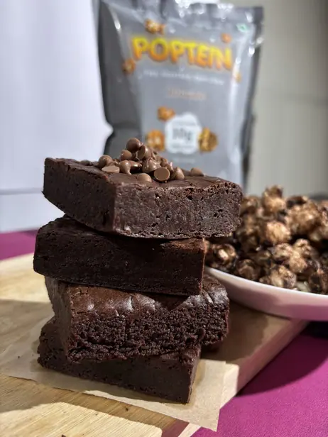 Stacked brownies beside a bowl of Brownie flavour Poptein