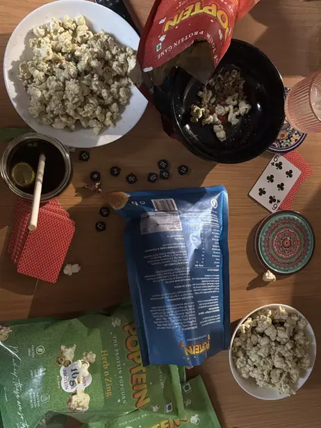 Herb n Zing and Peanut Butter packs on a kitchen table with card games