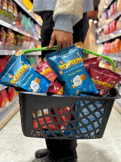 Shopping basket full of Poptein packs in a store