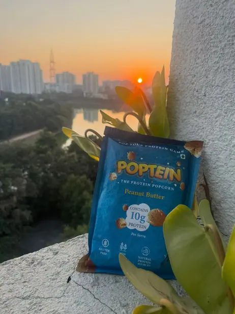Peanut Butter Poptein pack on a ledge at sunset