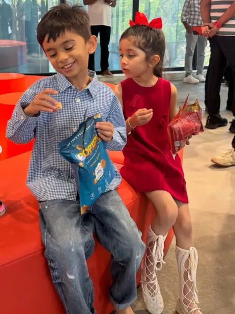 Two kids sharing a pack of Poptein at a street event